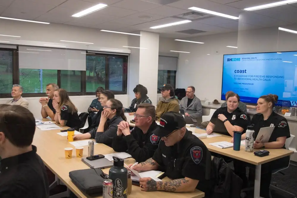 Members of the South County Fire department sit in a School of Social Work research commons classroom for a BHCore-led training session.