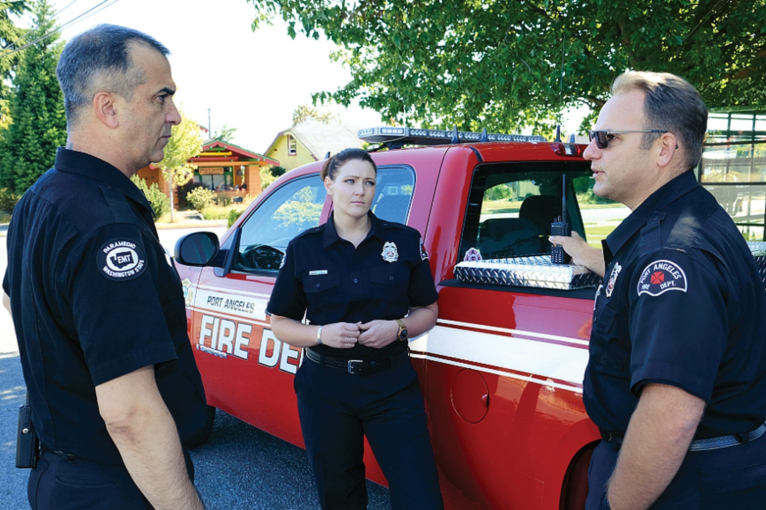 Firefighters standing near an emergency vehicle.