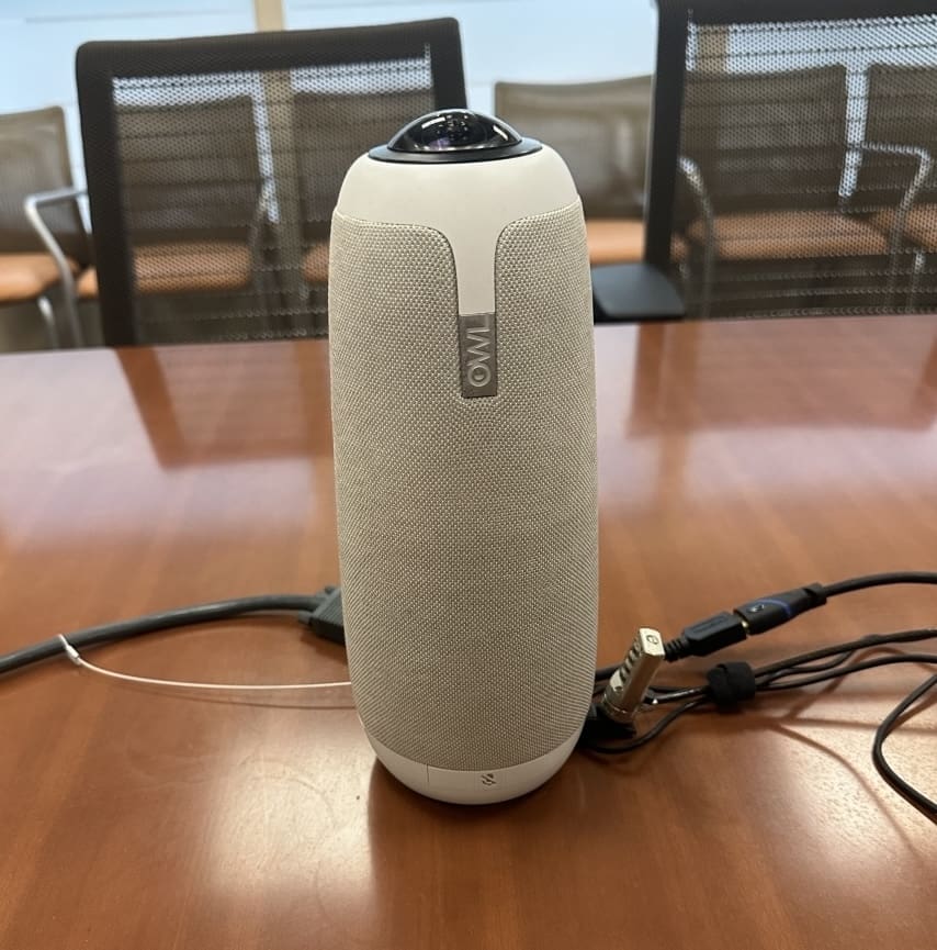 Tall white technology device called an OWL sitting on top of a brown desk